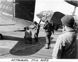 Signal Corps photo of men attaching wire-on-tow-line to C-47 for Market mission or the Varsity mission